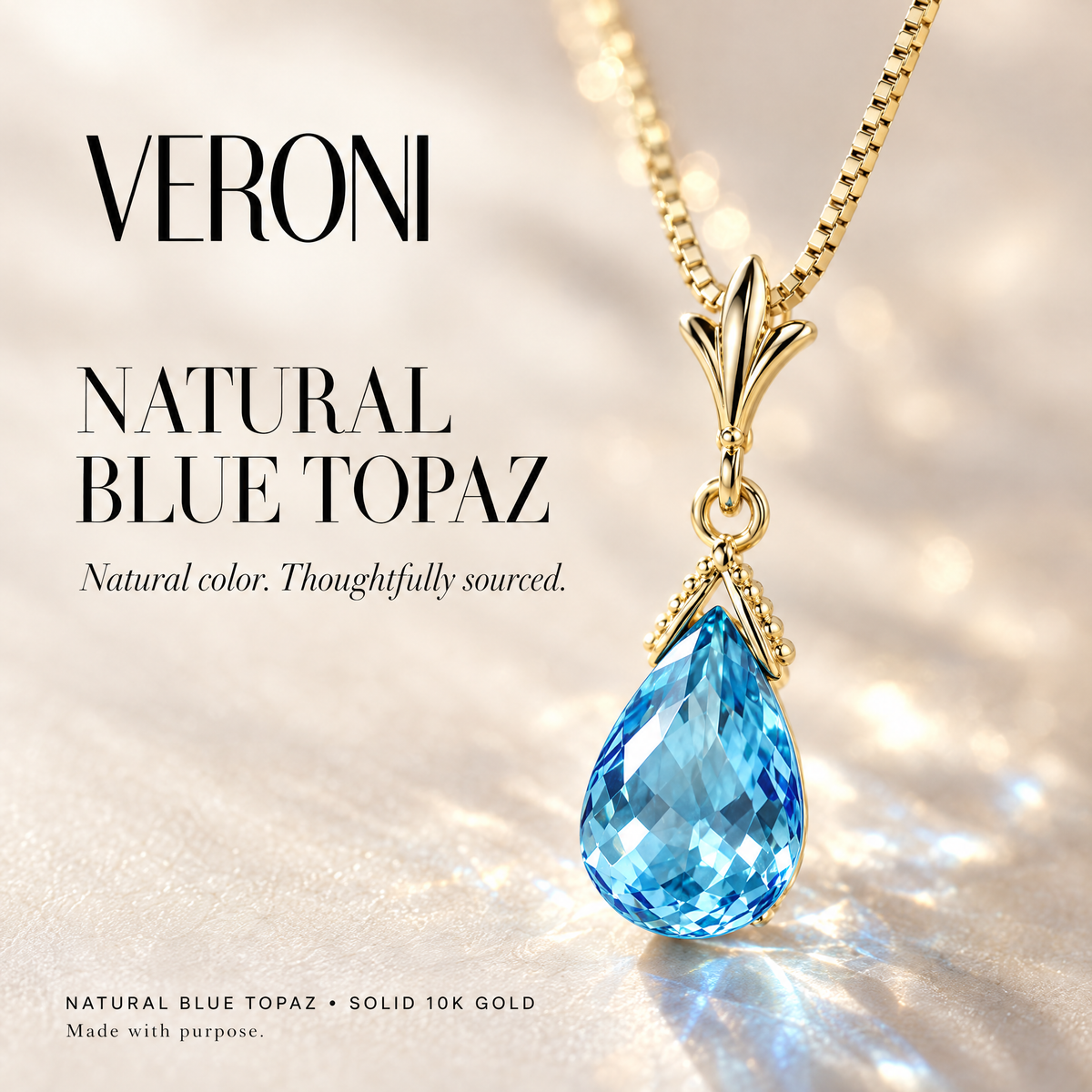 Yellow Gold Liana natural blue topaz pendant on a warm ivory background in a VERONI campaign.