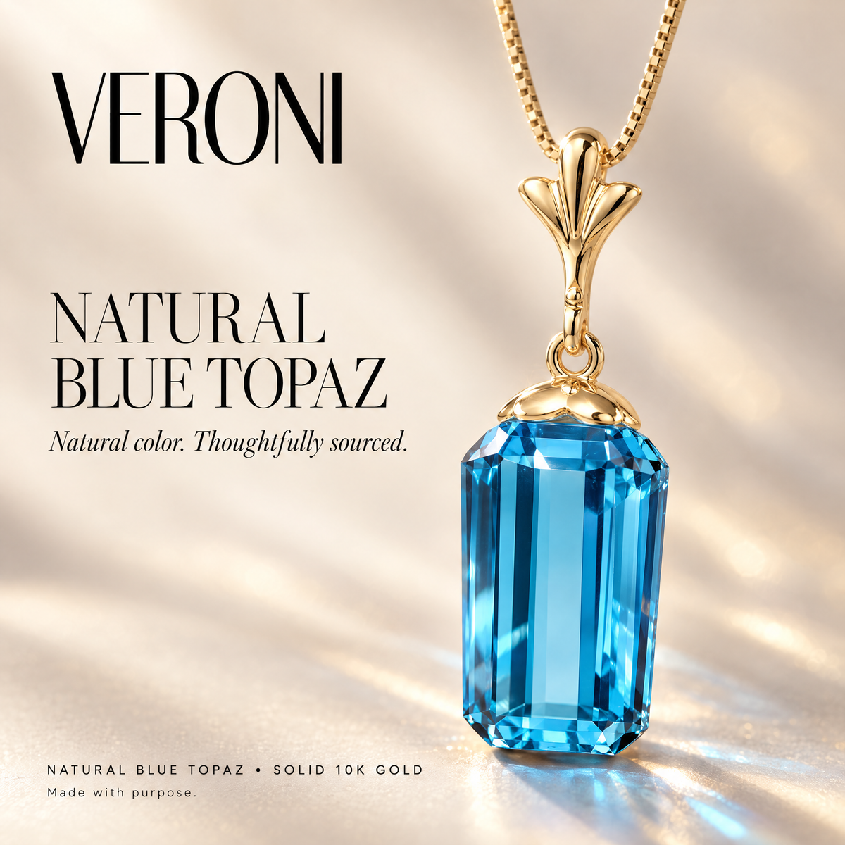 Yellow Gold Flora natural blue topaz pendant on a warm ivory background in a VERONI campaign.