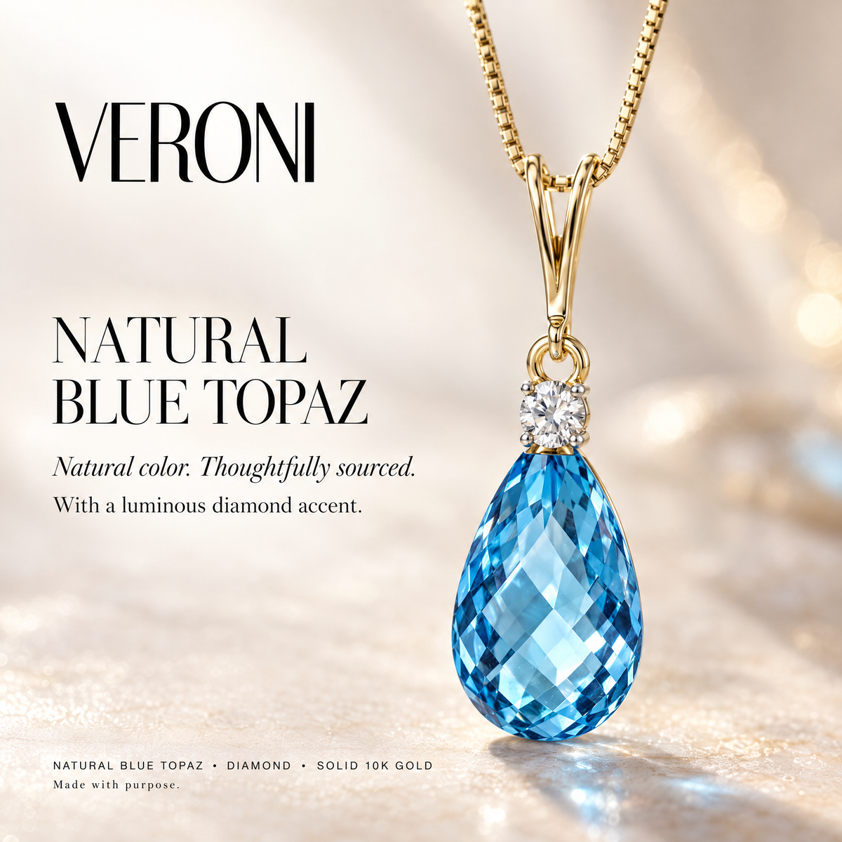 Yellow Gold Giorgia natural blue topaz and diamond pendant on a warm ivory background in a VERONI campaign.