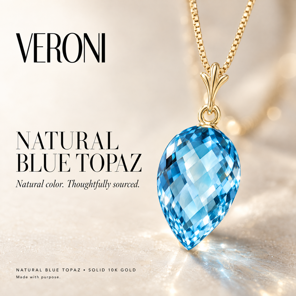 Yellow Gold Primavera natural blue topaz pendant on a warm ivory background in a VERONI campaign.