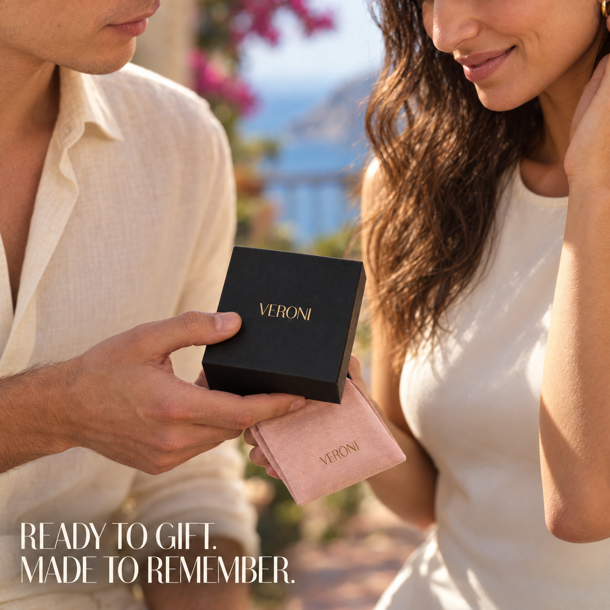 Close-up of a couple holding a black VERONI gift box and pink jewelry pouch. Ready to gift. Made to remember.